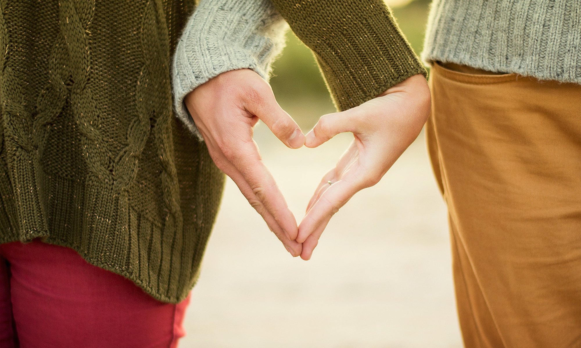 Two people being tender-hearted and forming a heart shape with their hands