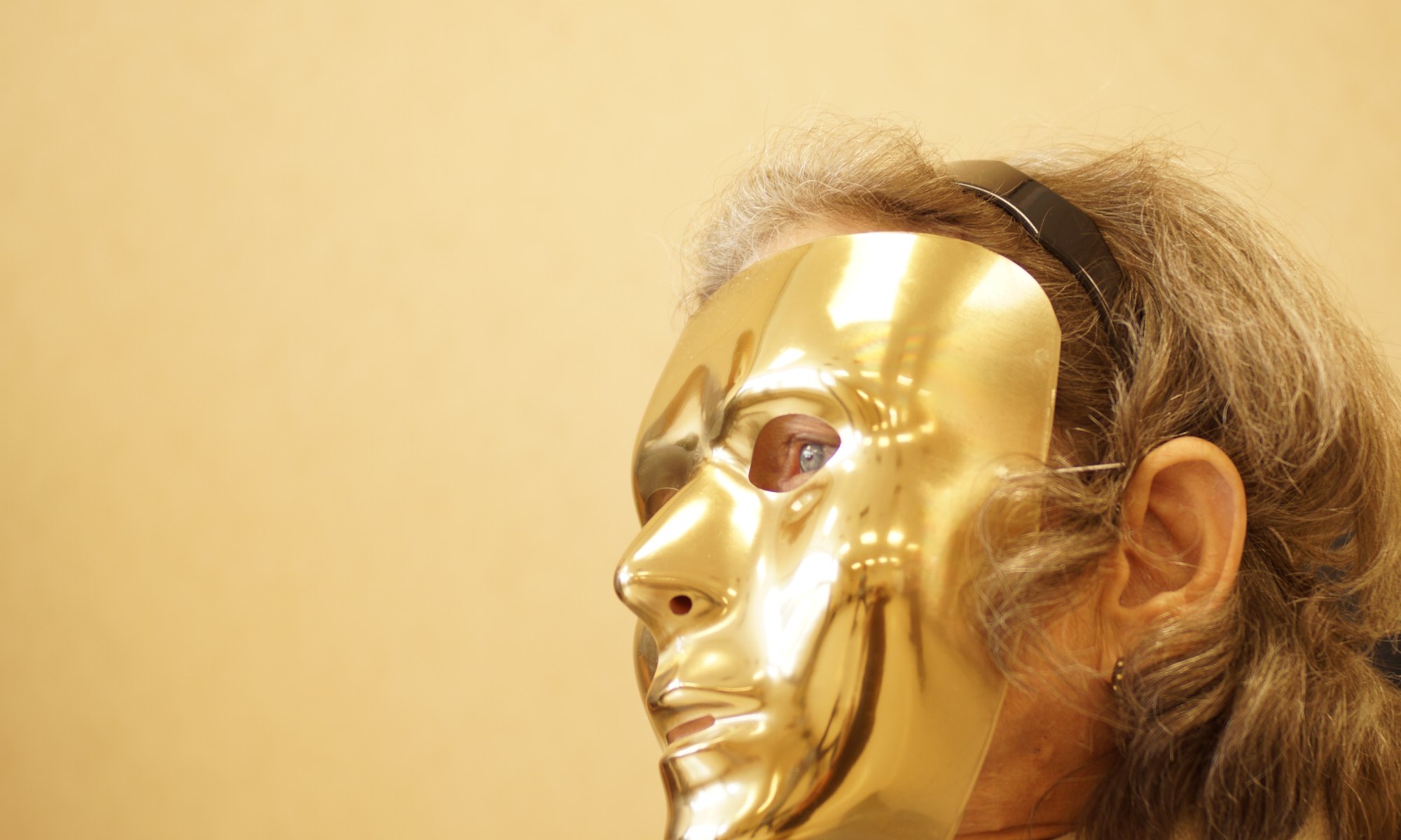 Person demonstrating theory of mind by wearing a gold mask