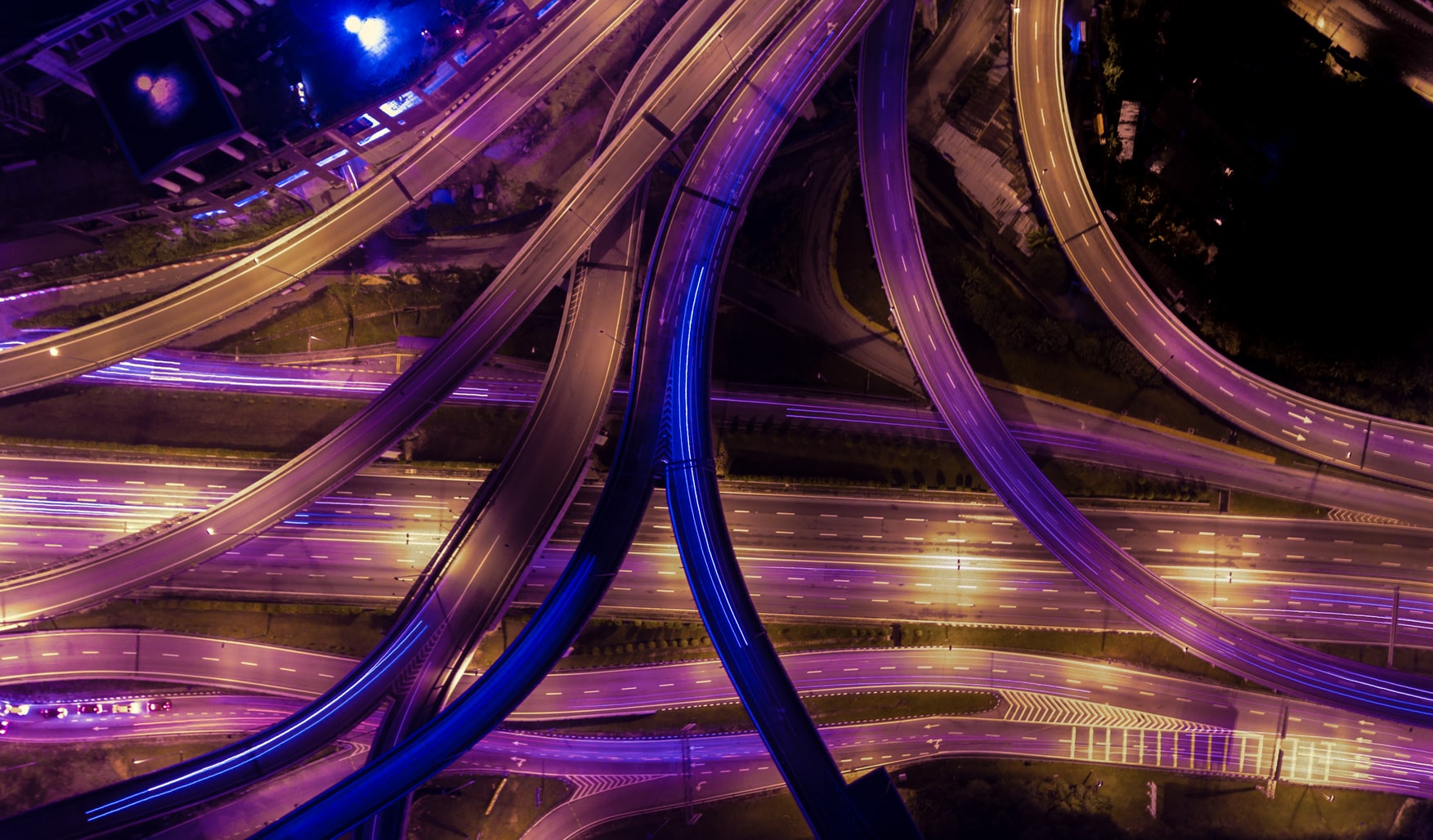 Aerial photography of colorful roads and highways merging during nighttime