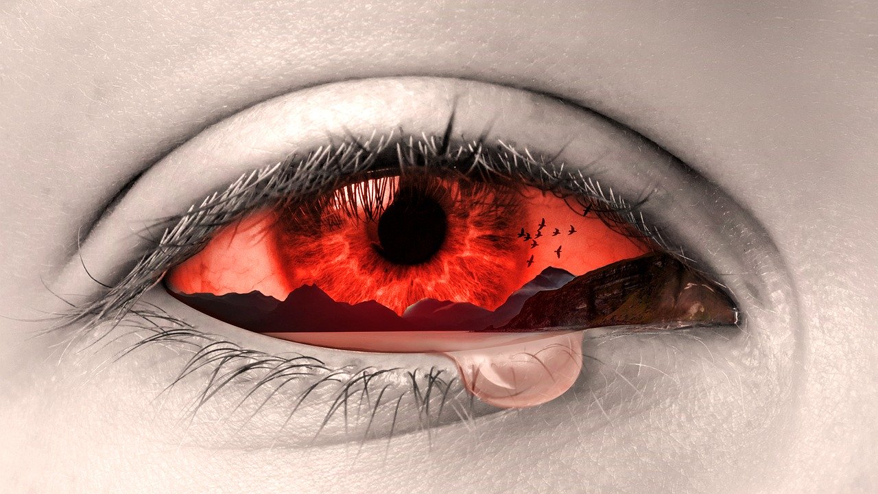 Red human eye with pink liquid dripping out